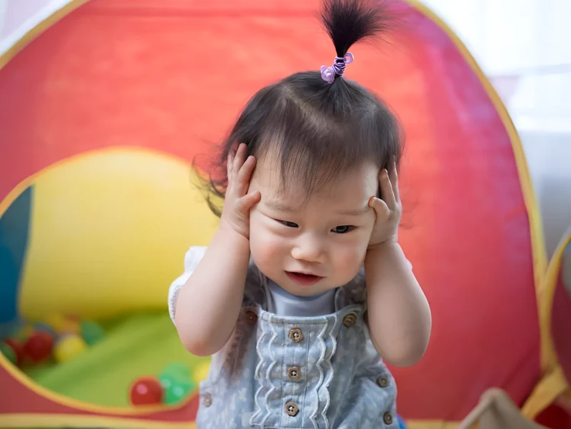 Be hay nắm chặt tay gồng mình khi chăm sóc trẻ